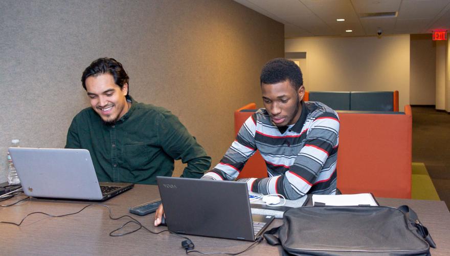 Two Male Graduate Students in School of Business on Laptops