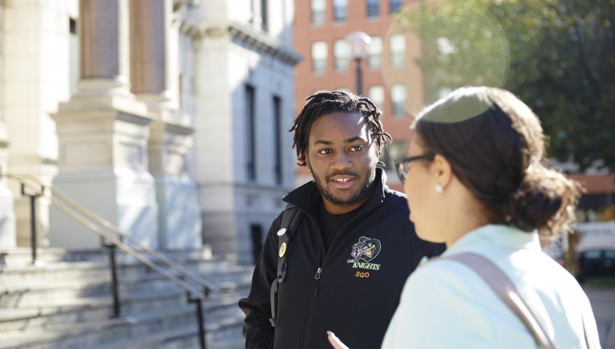 male and female student talking in front of city hall downtown jersey city