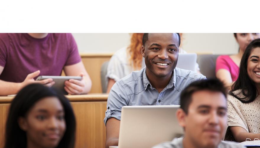 edu leadership male student smiling in lecture hall