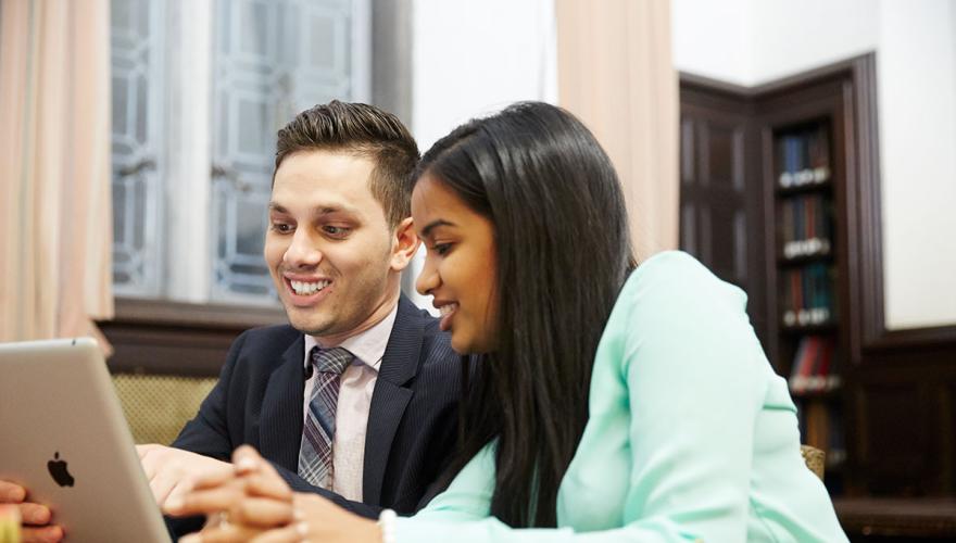 two students looking at a mobile tablet