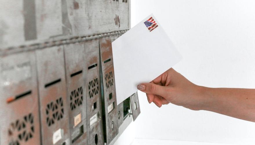 Person Mailing Envelope with American Flag