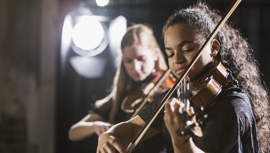 Two young women playing string instruments