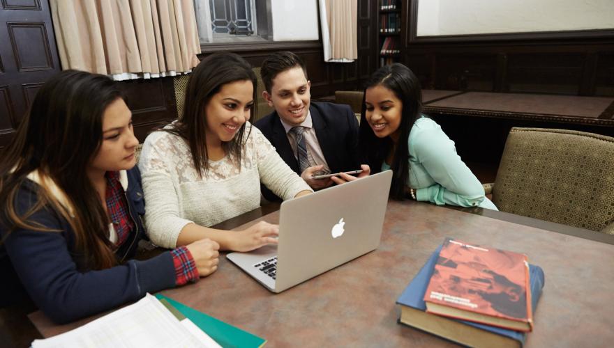 Students gather around a computer
