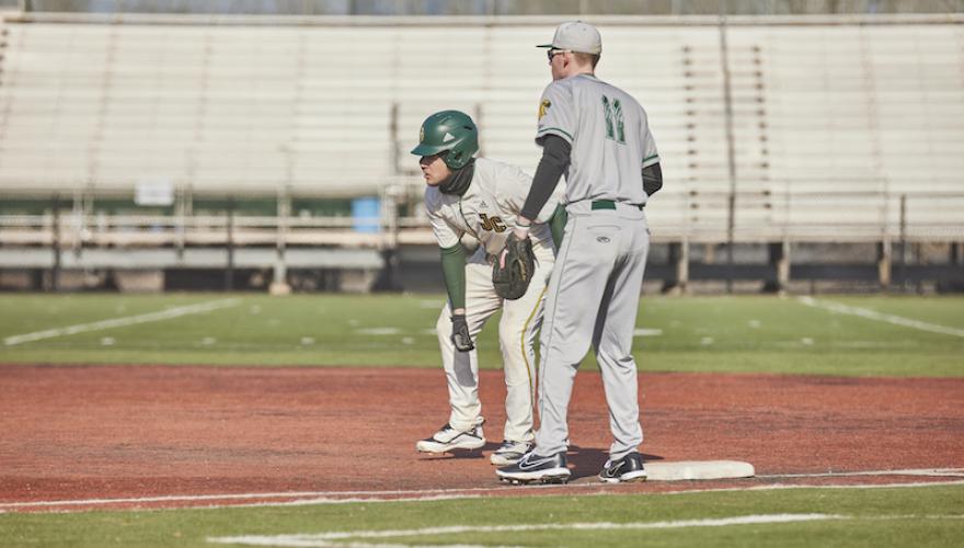 TWO MALE PLAYERS ON BASEBALL FIELD