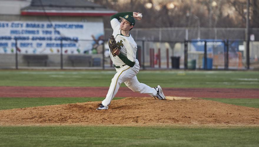 MALE PITCHES BASEBALL ON FIELD