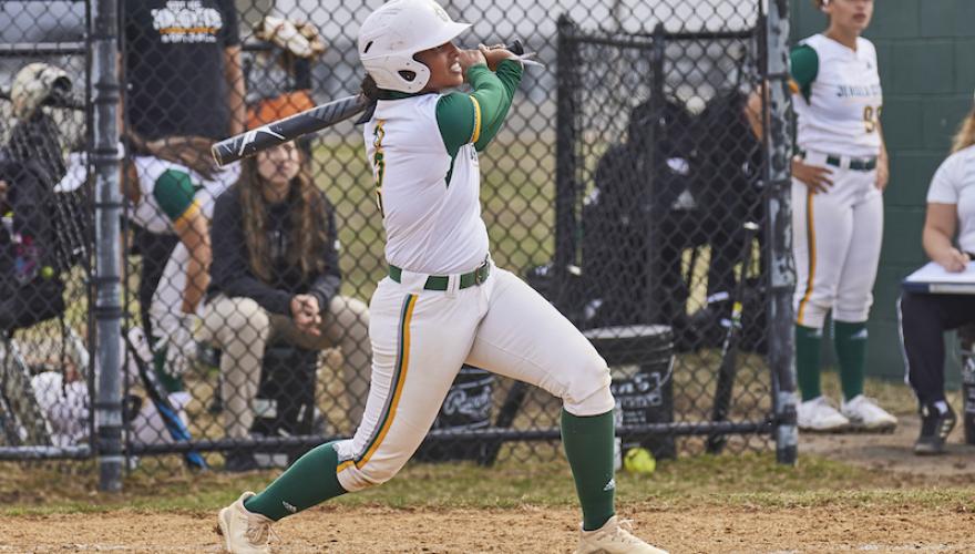 woman swinging bat in softball game