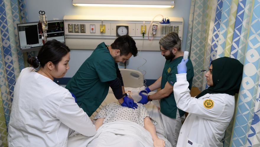 4 nursing students training w mannequin