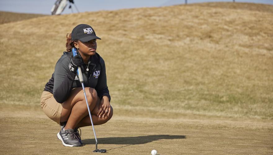 GOLF PLAYER WOMAN KNEELING NEAR BALL
