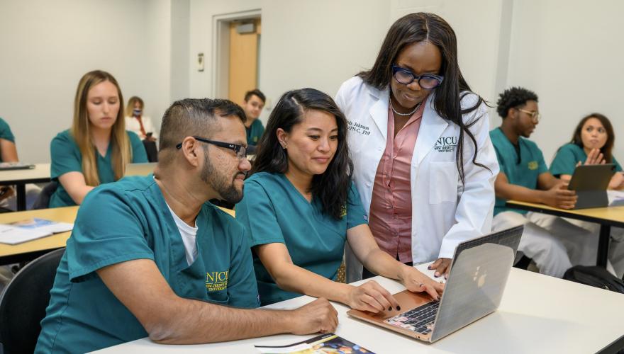 Nursing students being helped by professor in class