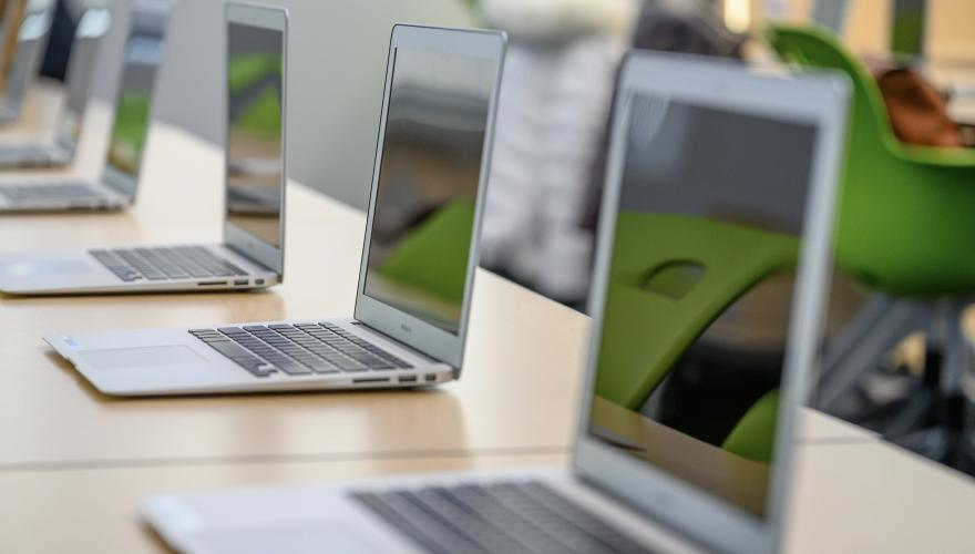Row of MacBooks on tables in Nursing classroom