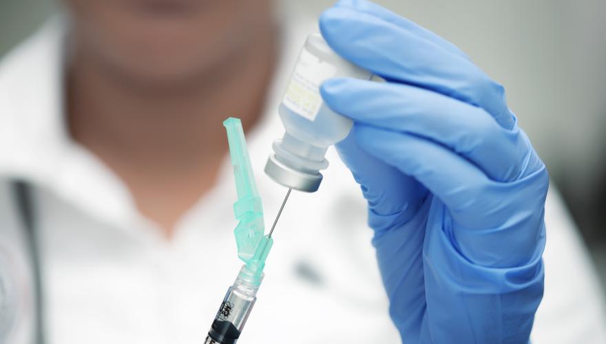 Vaccine being added to syringe