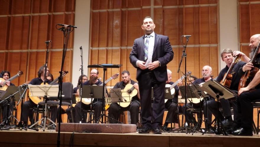 JAYSON MARTINEZ STANDING WITH SEATED MUSICIANS BEHIND