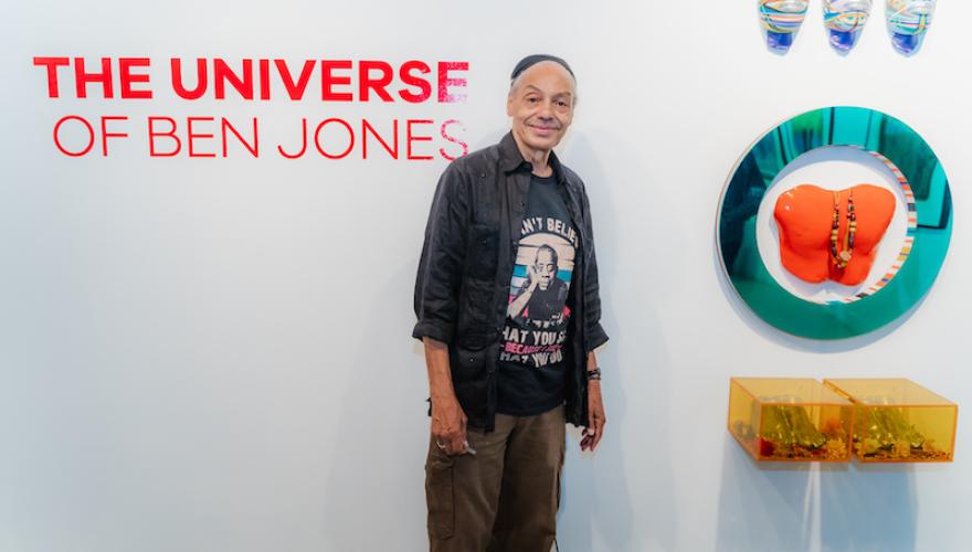 ben jones stands against wall with art