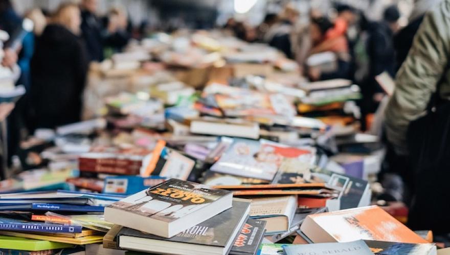PILES OF BOOKS ON TABLES