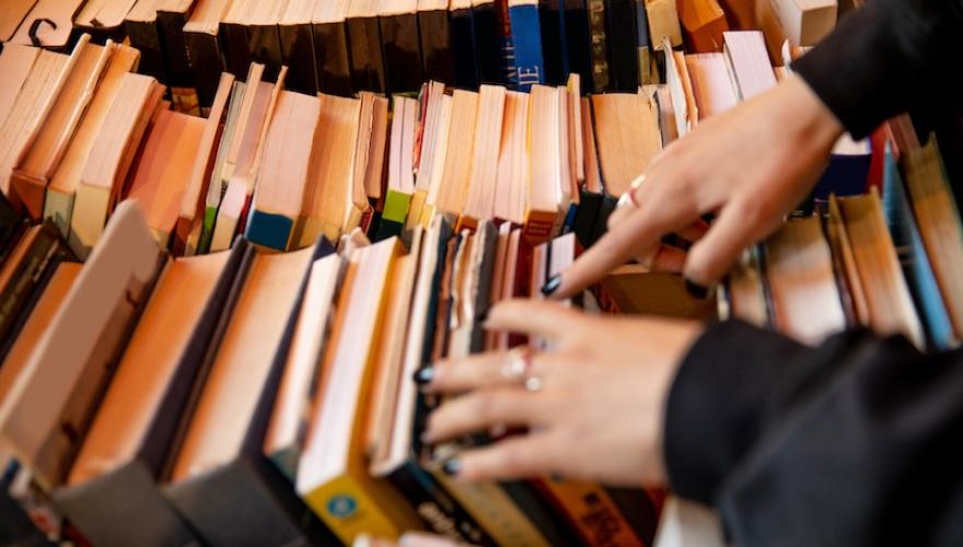 FEMALE HANDS SORT THROUGH BOOKS