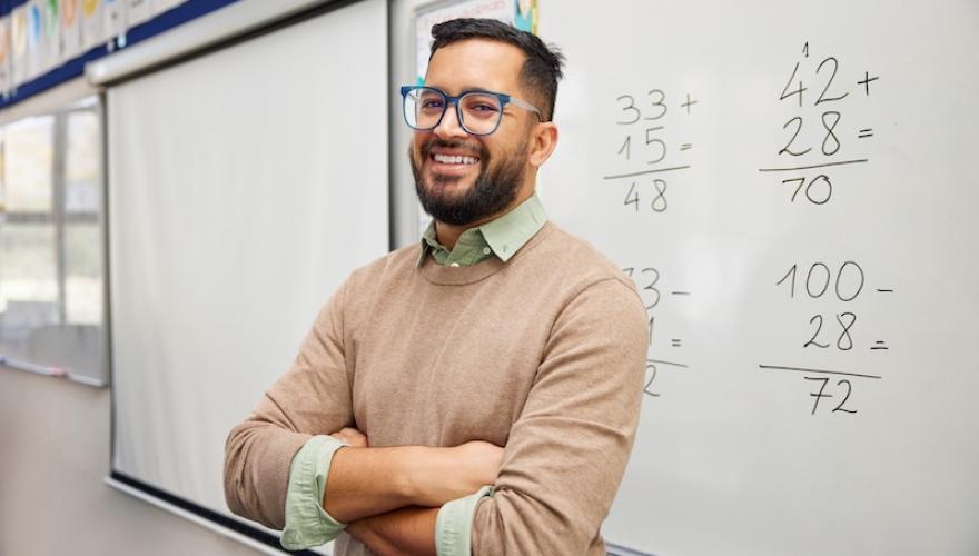 math teacher stands at blackboard