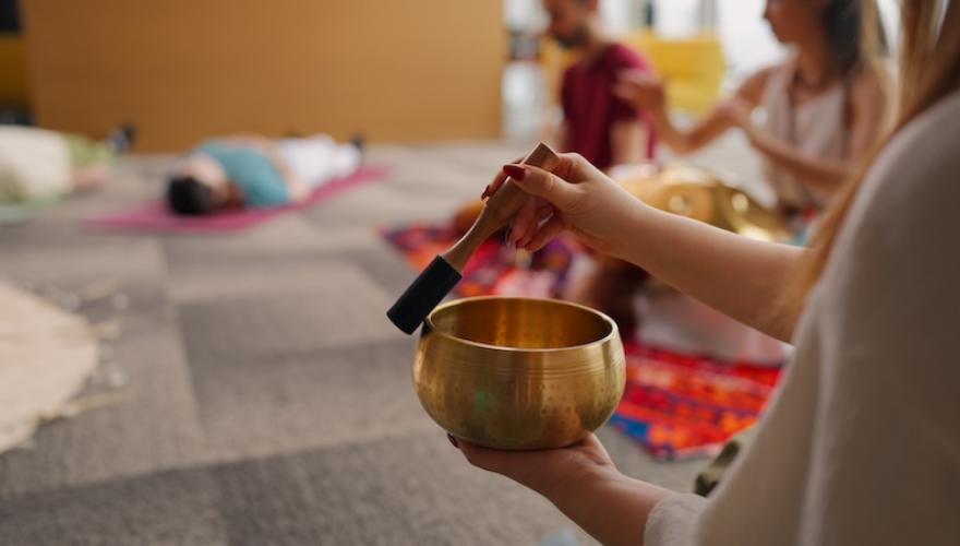 SOUND THERAPY GROUP CLOSEUP OF BOWL AND INSTRUCTOR HANDS