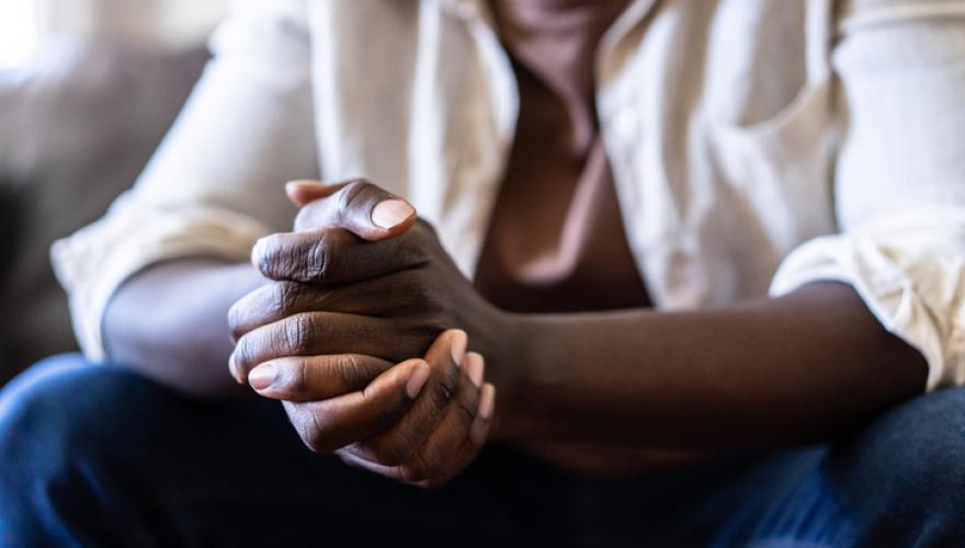 black seated male clasped hands