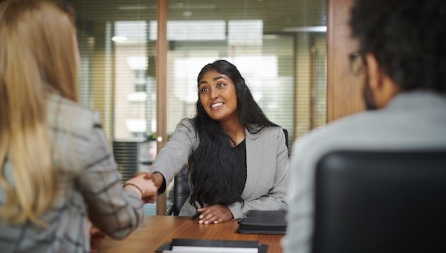 woman extends hand across table to couple
