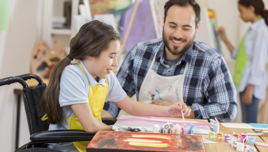 male seated with child in wheelchair