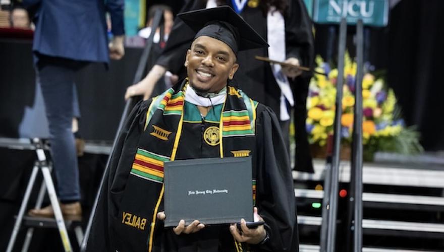 graduating student poses with degree
