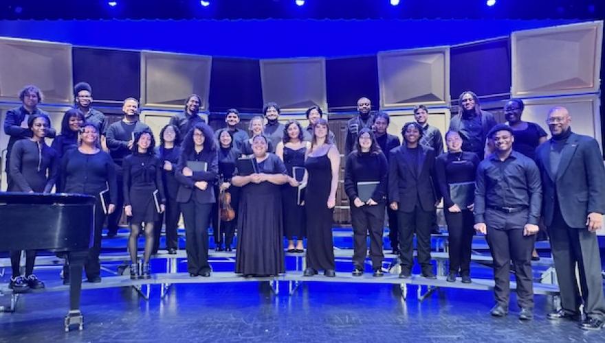 group of singers stand on stage posed