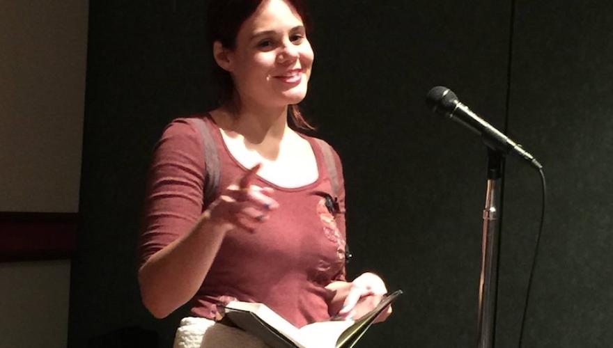 Margaux Fragoso at microphone with book