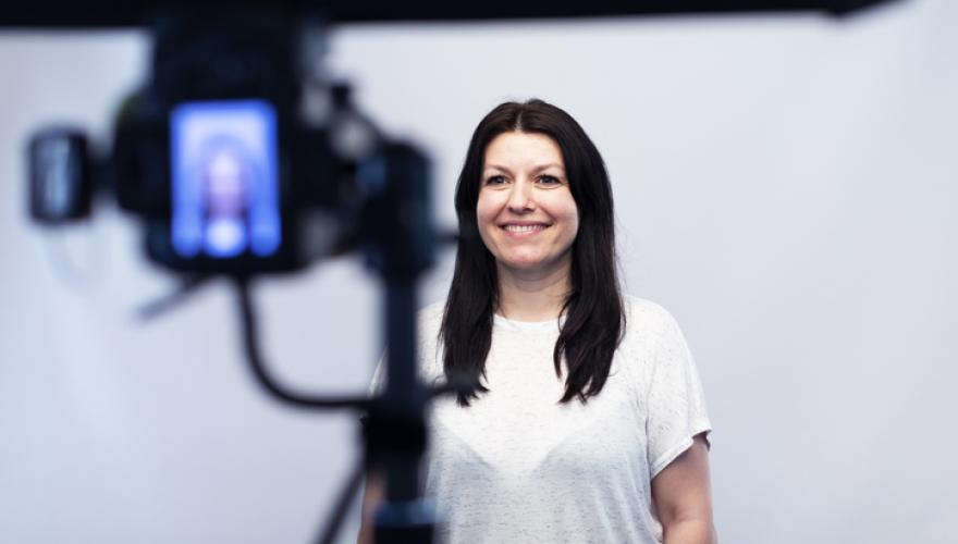 standing camera takes photo of woman