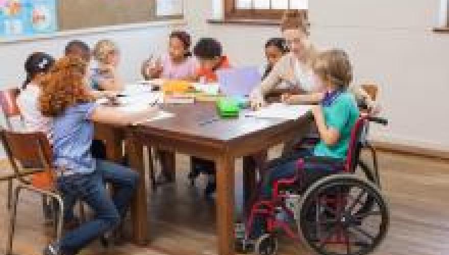 Teacher helping a student in a wheelchair