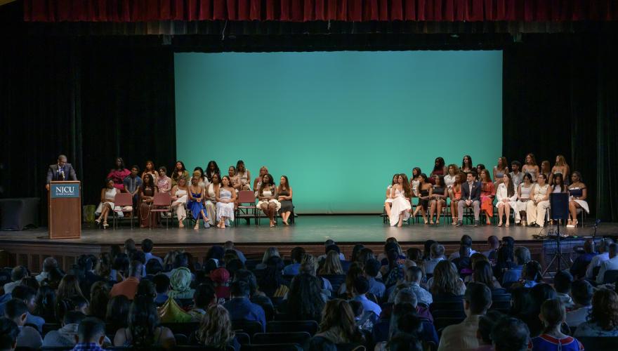 BSN students on stage at the Margaret Williams Theatre during the 2025 BSN pinning ceremony.