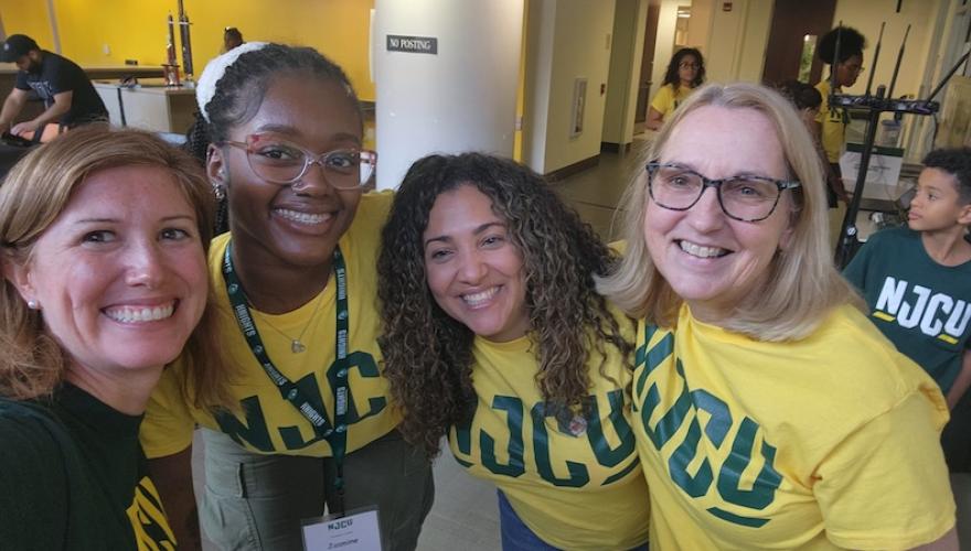 staff and students pose wearing njcu shirts