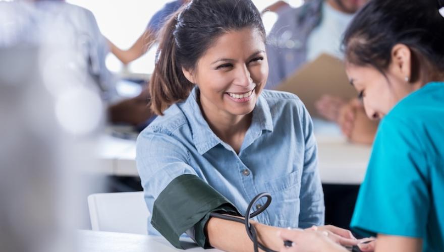 blood pressure check done by nurse to female patient