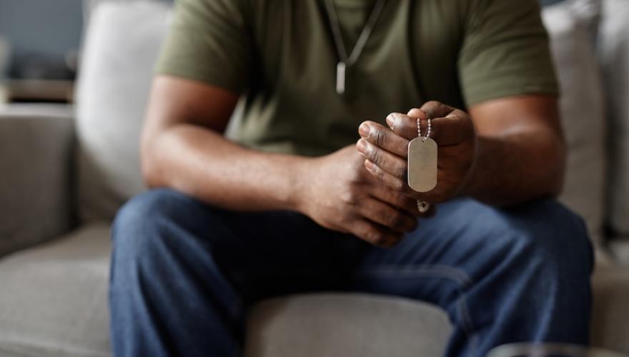 military man seated holding tags