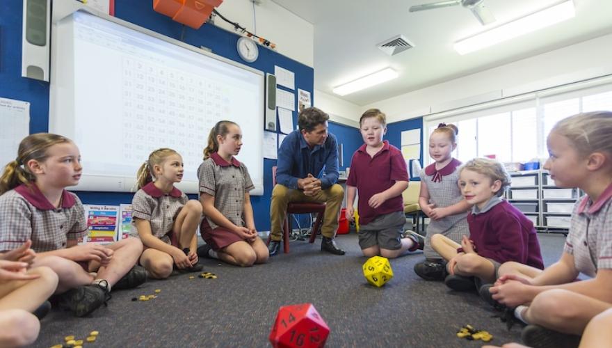 schoolkids seated with teacher for game