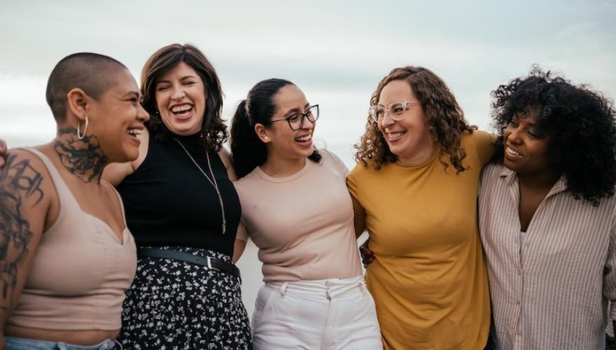 women laughing and hugging outdoors