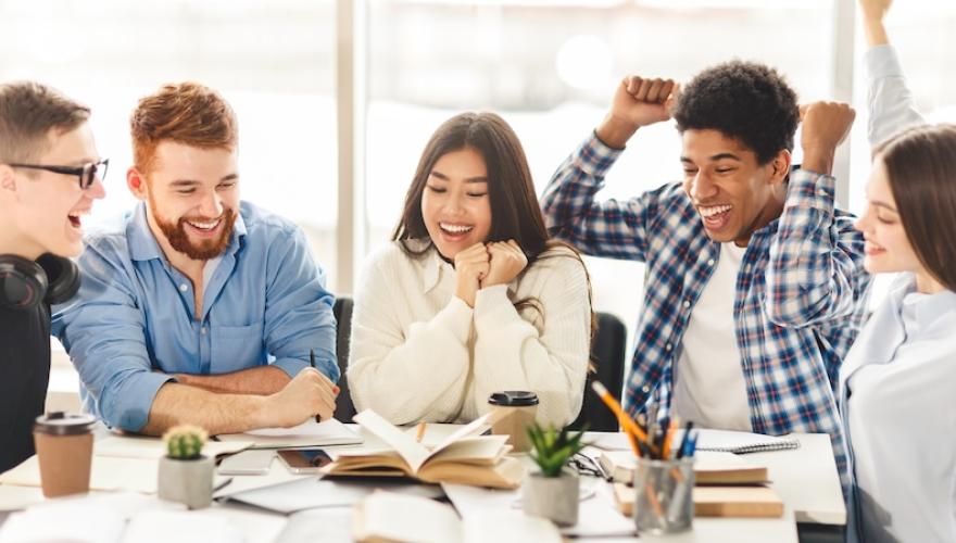 seated students excited about project, raised hands