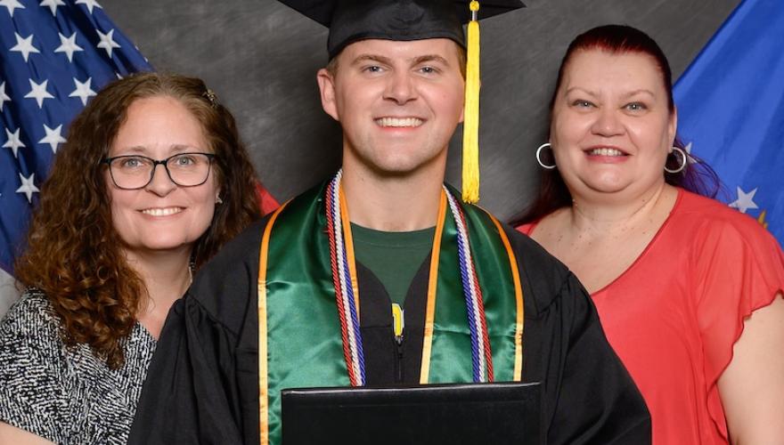 graduate poses with Military and veteran services staff