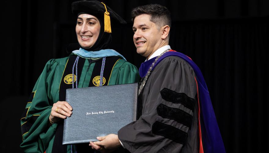 President Acebo poses with a new doctoral graduate of NJCU's Ed.D. program.