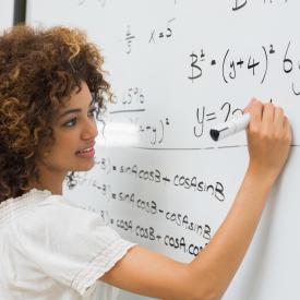 female student doing math on whiteboard