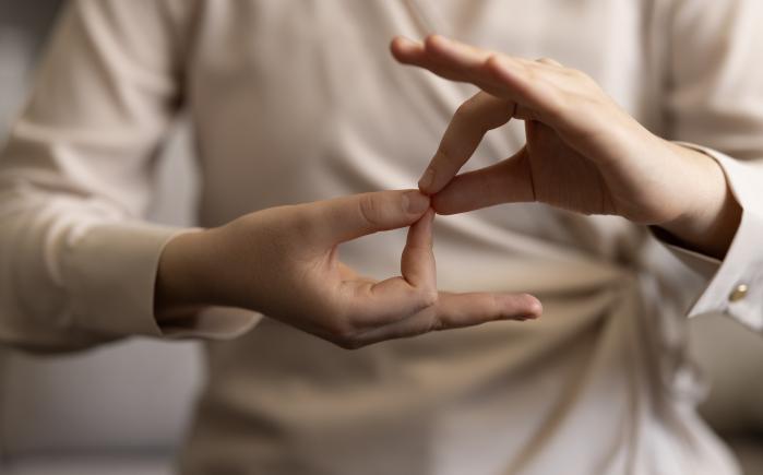 Woman using sign language - stock photo GettyImages-1960781418