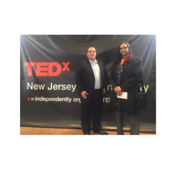 Two gentlemen in front of TEDx sign