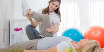 physical therapist aide working on a patient
