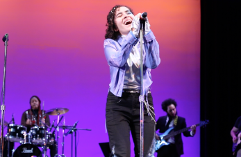singer belting out front and center with base and percussion in the background