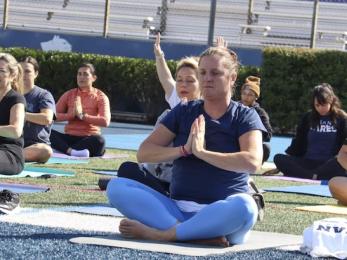 Wellness class with students doing a meditative pose.