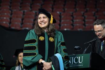 A doctoral student is beaming as her name is read.